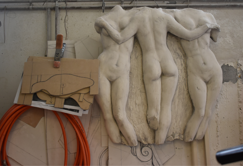 The photo is taken inside the Hondrogiannis workshop and it depicts the detail of the sculptural relief and sketches around it.